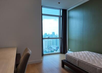 Bedroom with large window and view of the city