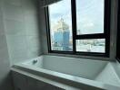 Bathroom with a bathtub and a city view