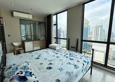 Modern bedroom with large windows and city view