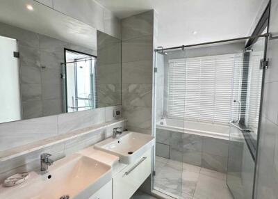 Modern bathroom with dual sinks and a walk-in shower