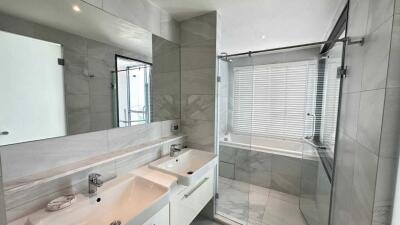 Modern bathroom with dual sinks and a walk-in shower