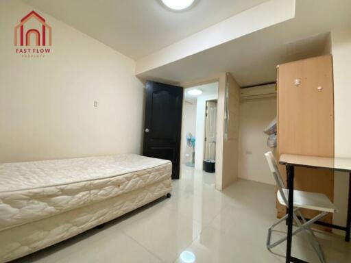 Simple furnished bedroom with single bed and study area