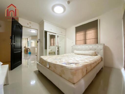 Spacious bedroom with a double bed, closet, and large windows