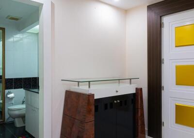 Entry area to bathroom with visible toilet and modern door
