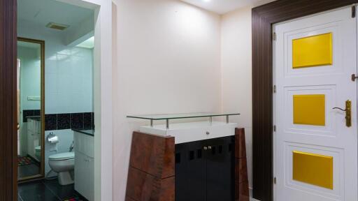 Entry area to bathroom with visible toilet and modern door