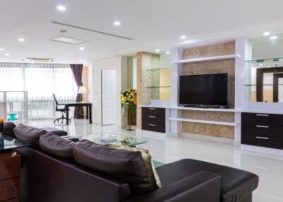 Modern, spacious living room with entertainment center and work desk