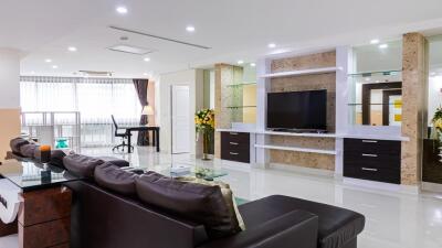 Modern, spacious living room with entertainment center and work desk