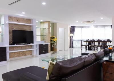 Modern living room with built-in TV unit and dining area
