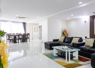 Modern living room with dining area in the background