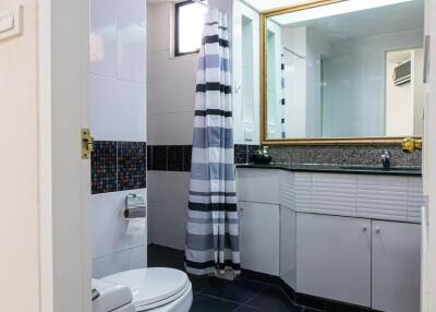 Bathroom with striped shower curtain and large mirror