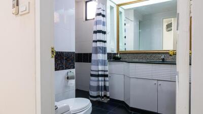 Bathroom with striped shower curtain and large mirror