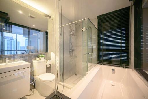 Modern bathroom with glass shower, bathtub, and city view