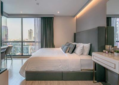Modern bedroom with large bed and city view from window