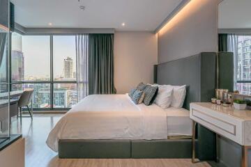 Modern bedroom with large bed and city view from window