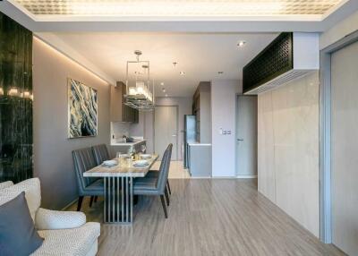 Modern dining area with table set for four, adjacent to kitchen