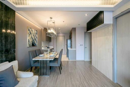 Modern dining area with table set for four, adjacent to kitchen