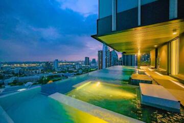 Rooftop infinity pool with city skyline view at dusk