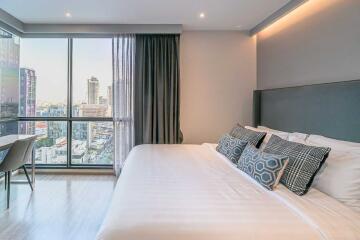 Modern bedroom with large window and urban view