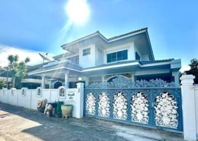 Exterior view of a two-story house with a decorative front gate