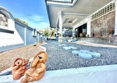 Front view of a house with a gravel garden and ceramic statues