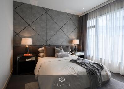 Modern bedroom with geometric accent wall and large windows