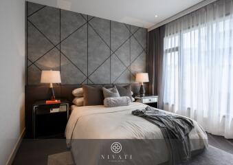 Modern bedroom with geometric accent wall and large windows