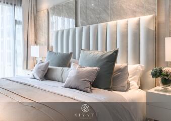 Luxurious bedroom setup with a large bed, decorative pillows, and ambient lighting