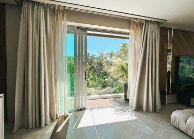 Bright living room with large glass sliding doors and a view of greenery outside