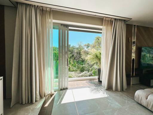 Bright living room with large glass sliding doors and a view of greenery outside