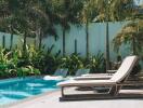 Luxury outdoor pool area with lounge chairs and palm trees