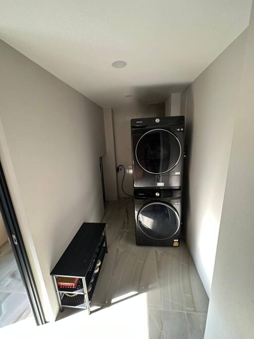 Modern laundry room with stacked washer and dryer