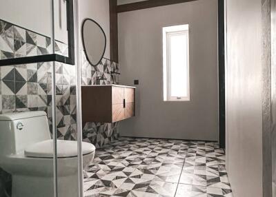 Modern bathroom with geometric tiles and glass shower door
