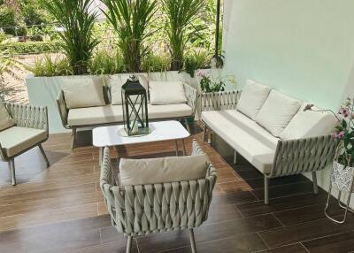 A cozy balcony with seating area and greenery