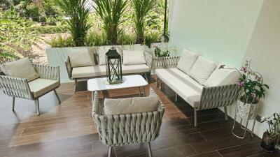 A cozy balcony with seating area and greenery