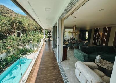Spacious living area with open layout, pool view, and adjacent balcony