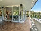 Spacious balcony with modern furniture and large glass doors