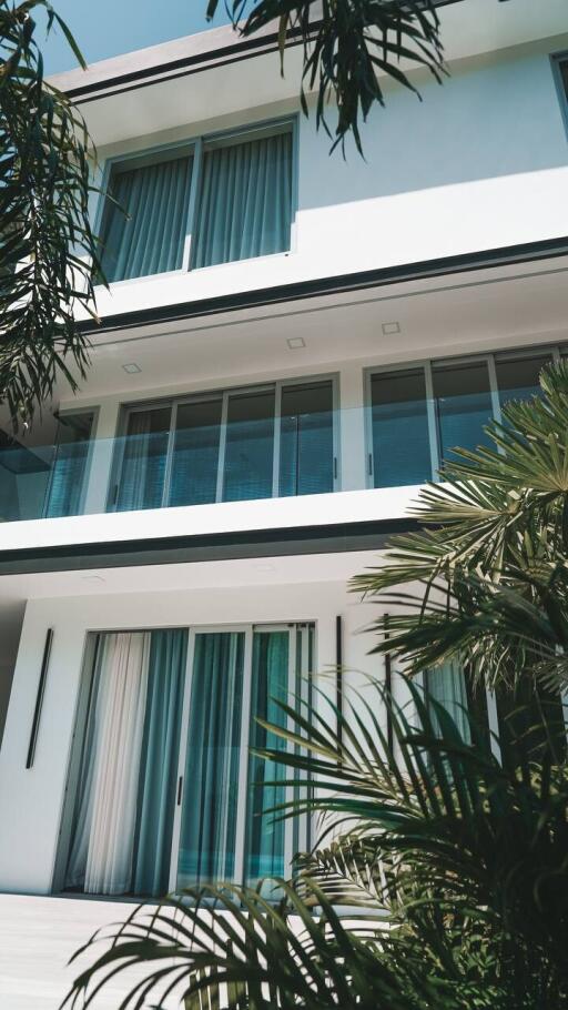 Modern exterior of a multi-story home with large windows and balcony