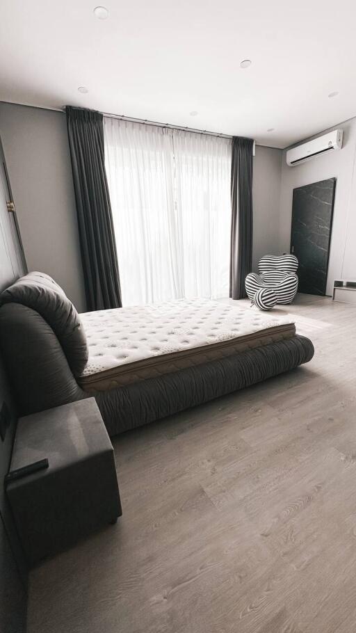 Modern minimalist bedroom with bed, curtains, and air conditioner