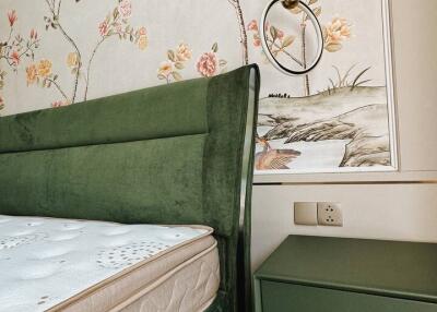 Bedroom with green bed and decorative wallpaper