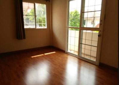 Empty room with large window and glass door to balcony