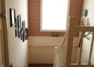 Stairwell with framed photos and a large window