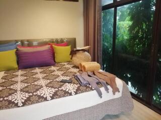 Bedroom with colorful pillows and large window