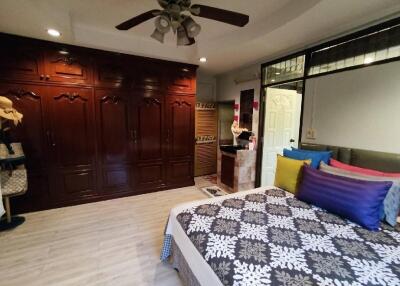 Spacious bedroom with wooden wardrobe and ceiling fan