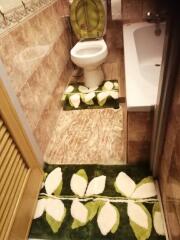 Bathroom with green floral rugs