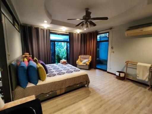 Spacious bedroom with double bed, ceiling fan, and ample natural light