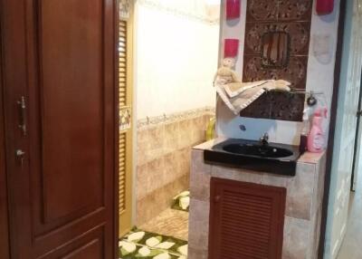 A well-maintained bathroom with wooden cabinets and decorative tiles