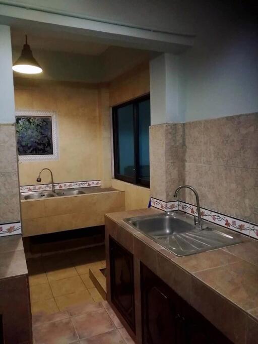 kitchen with tiled surfaces, sink, and artwork