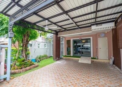 Covered carport area with tiled flooring and garden view