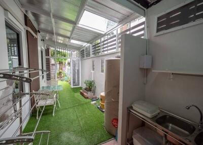 Covered outdoor area with synthetic grass and utility sink