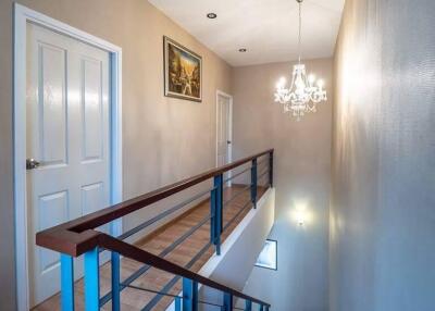 Interior view of a staircase and hallway with chandelier